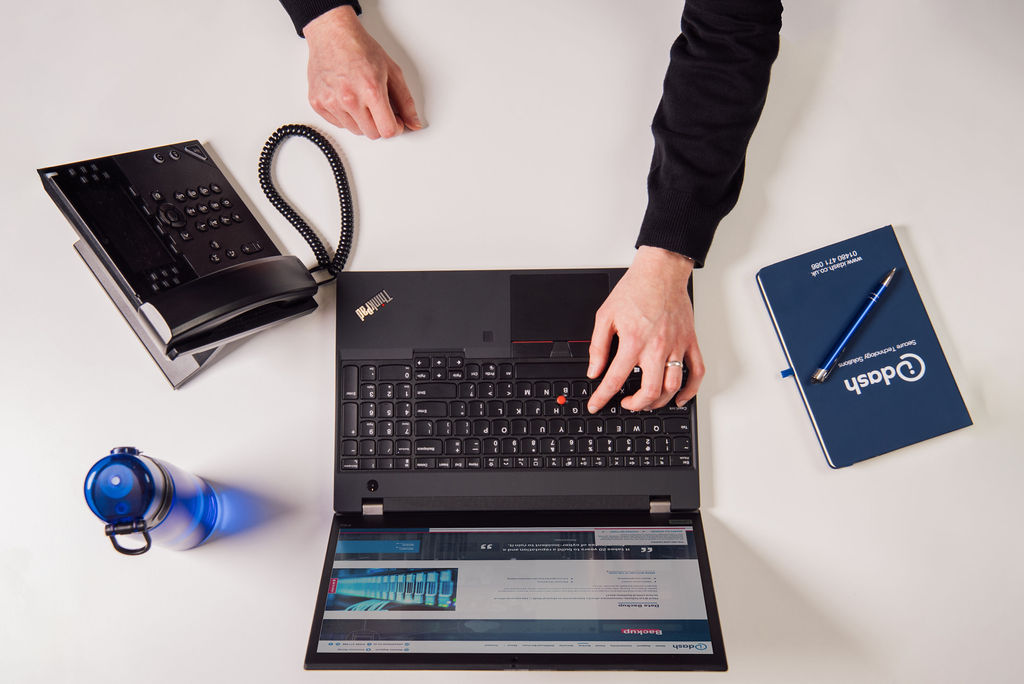 working on a laptop with phone